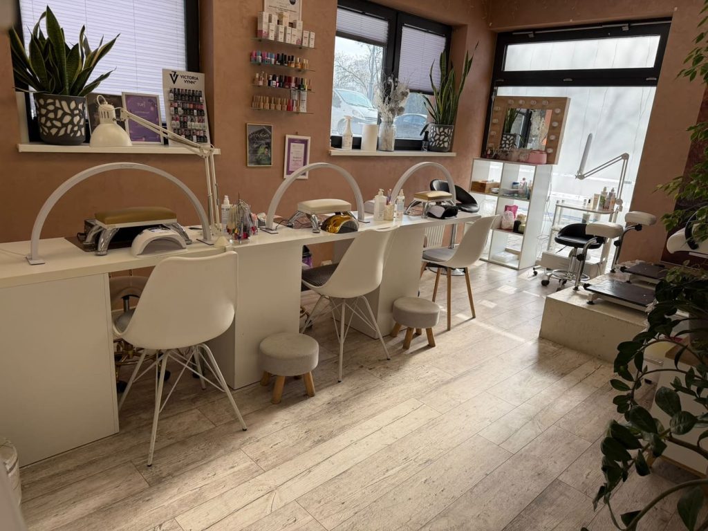 Stanowiska manicure i pedicure przy oknach — jasna część salonu